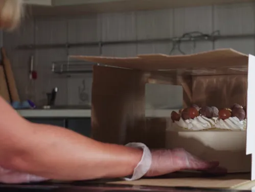 home baker places cake in box
