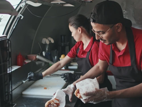people preparing food in food truck