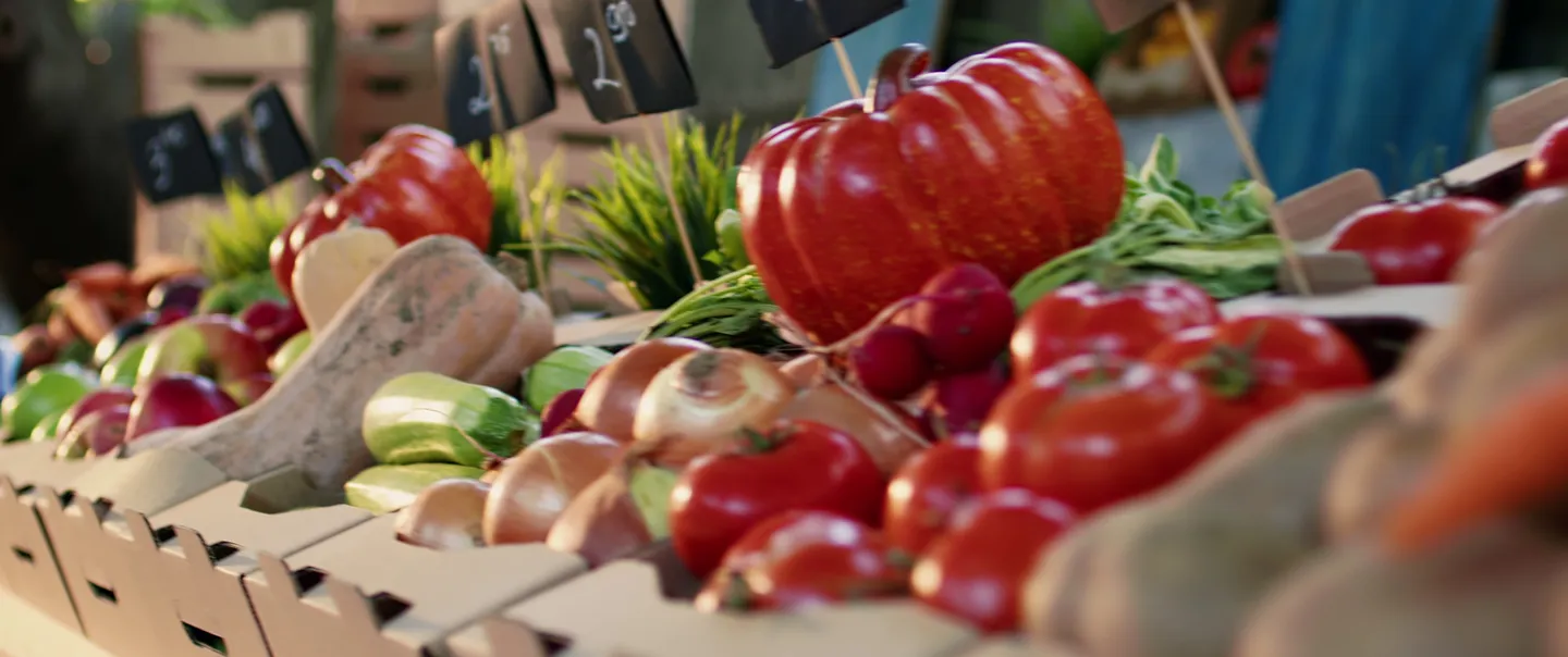 fresh vegetables in a basket at a farmers market booth