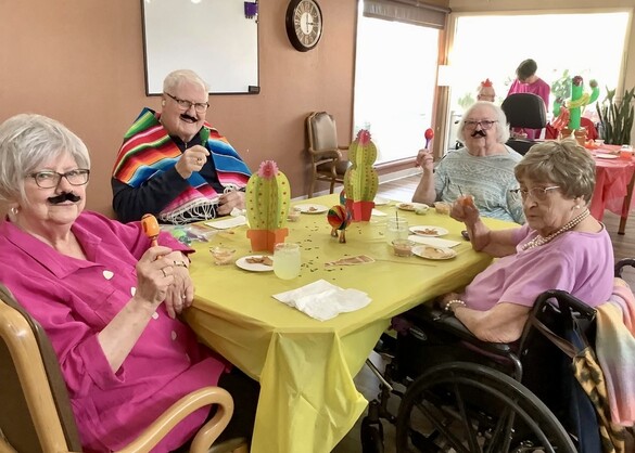 Four Briarwood residents around a table dressed in fiesta apparel.