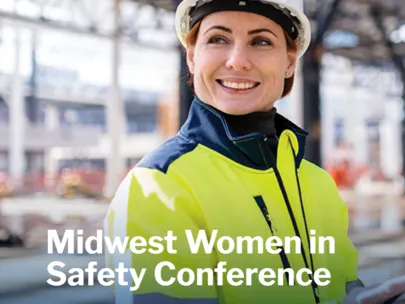 Woman wearing a hard hat and a reflective shirt at a construction site